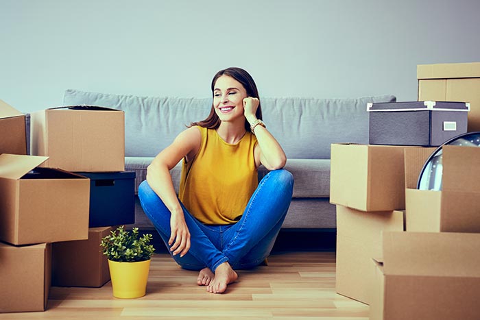 Women sitting in her new apartment covered by renter's insurance